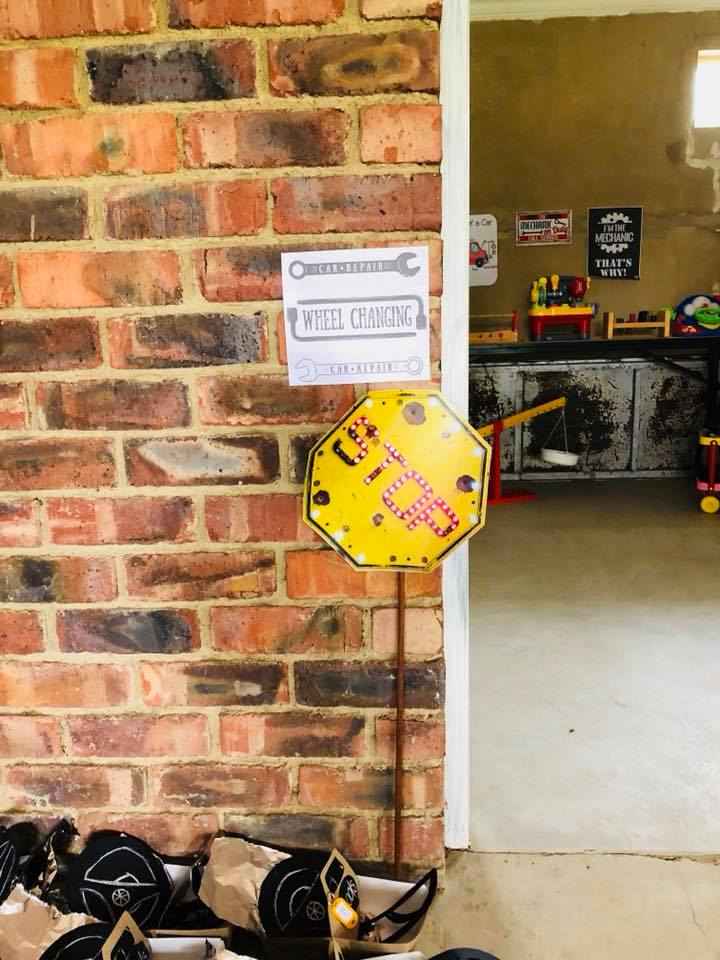 A brick wall with a sign, a yellow stop sign with lights for a kids birthday party