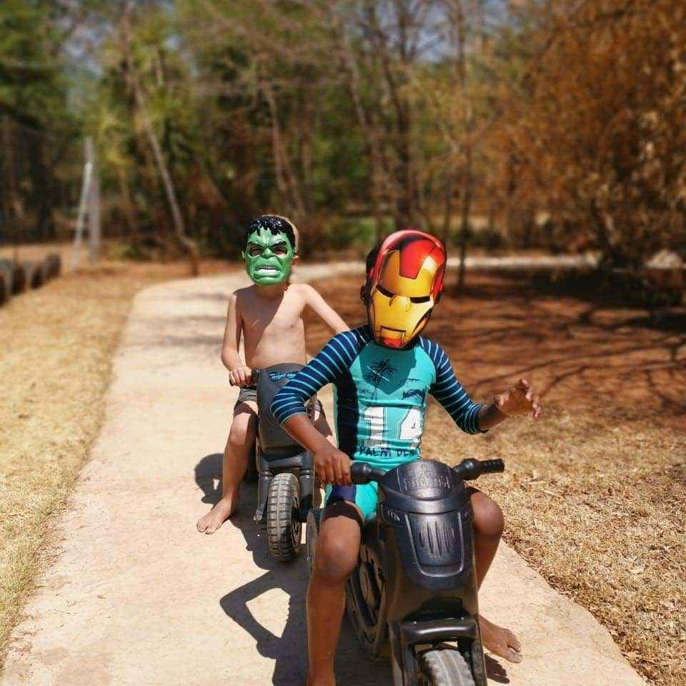 Two kids seated on a toy motorcycles riding on a dirt path at The Barn on Boundary Party Venue Johannesburg