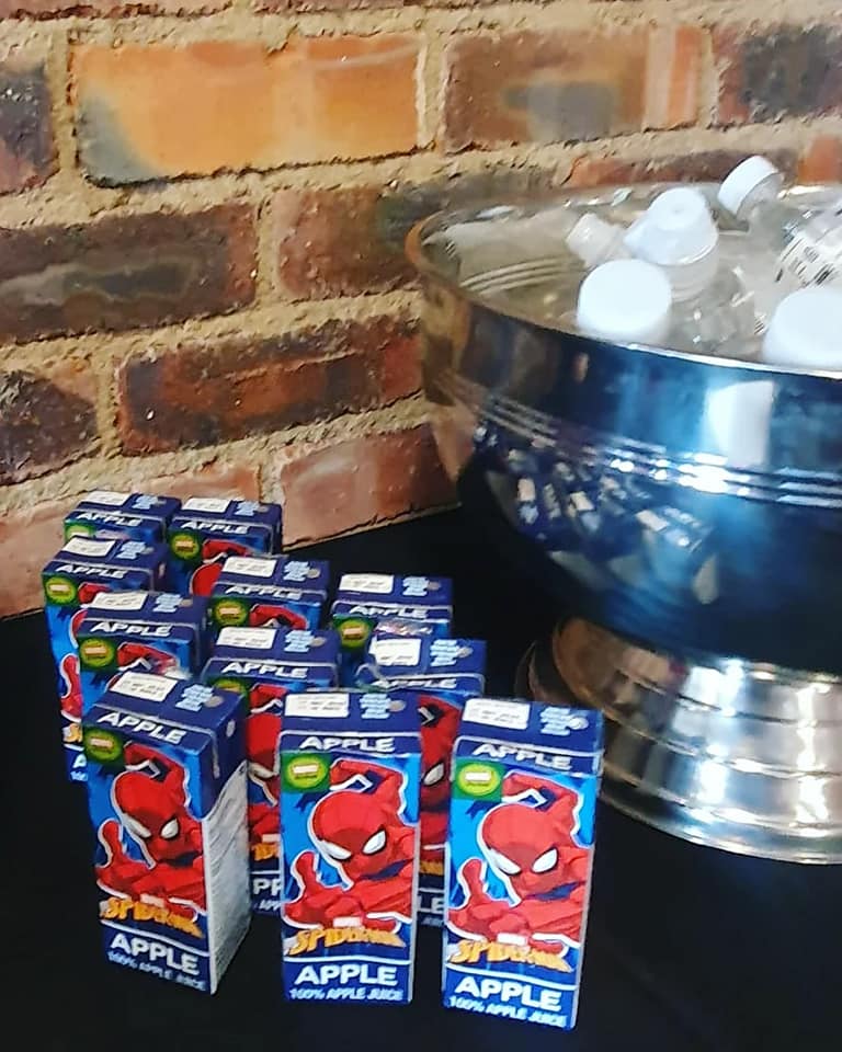Apple juice boxes with Spider-Man design and bottled waters in a silver bowl at Barn on Boundary Party Venue, Johannesburg.