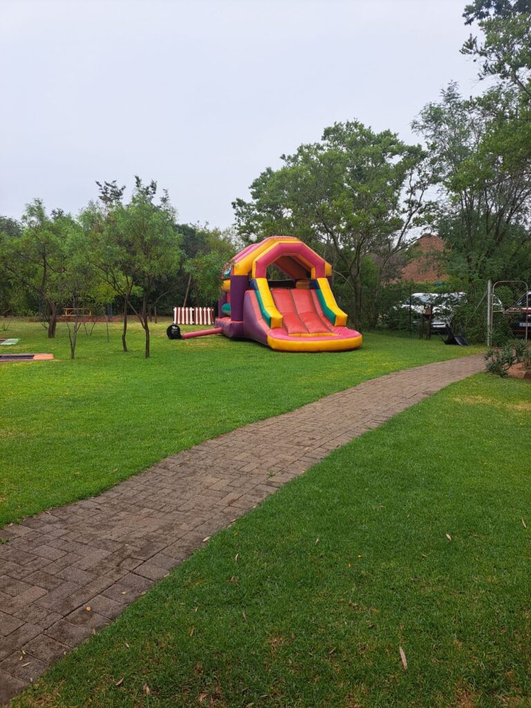 A colorful inflatable slide in the lush green garden of The Barn on Boundary Party Venue in Johannesburg, Northriding.
